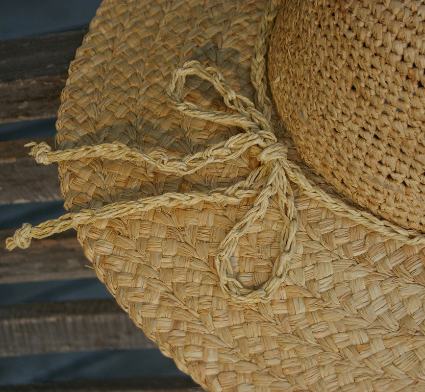 Close-up of a straw hat with a rope tie, blurred background