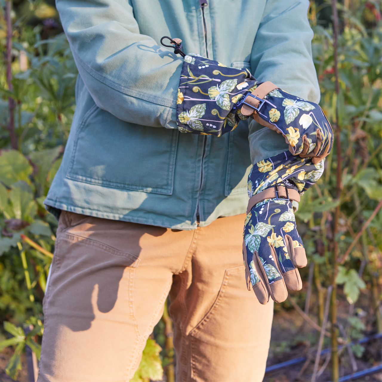 Person wearing floral gardening gloves in a garden setting