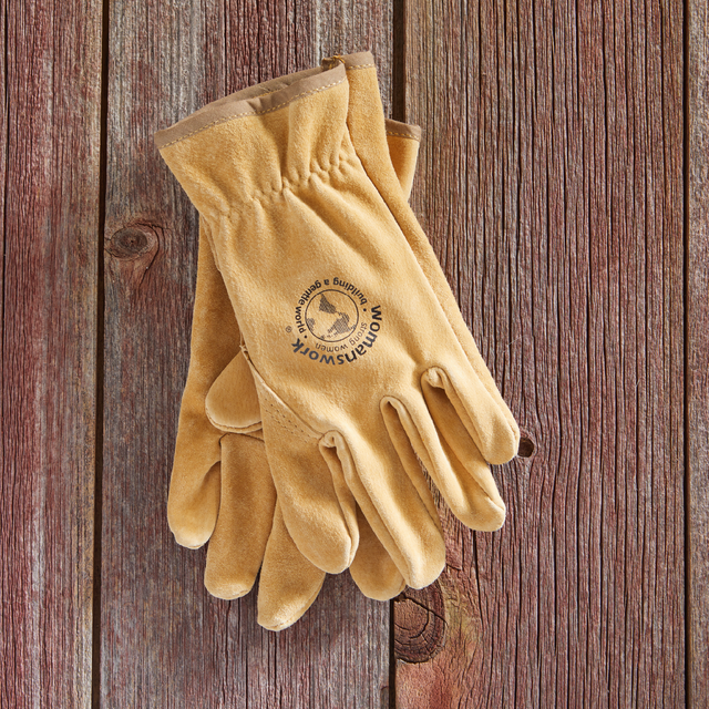 Pair of tan work gloves with womans work logo on a wooden background