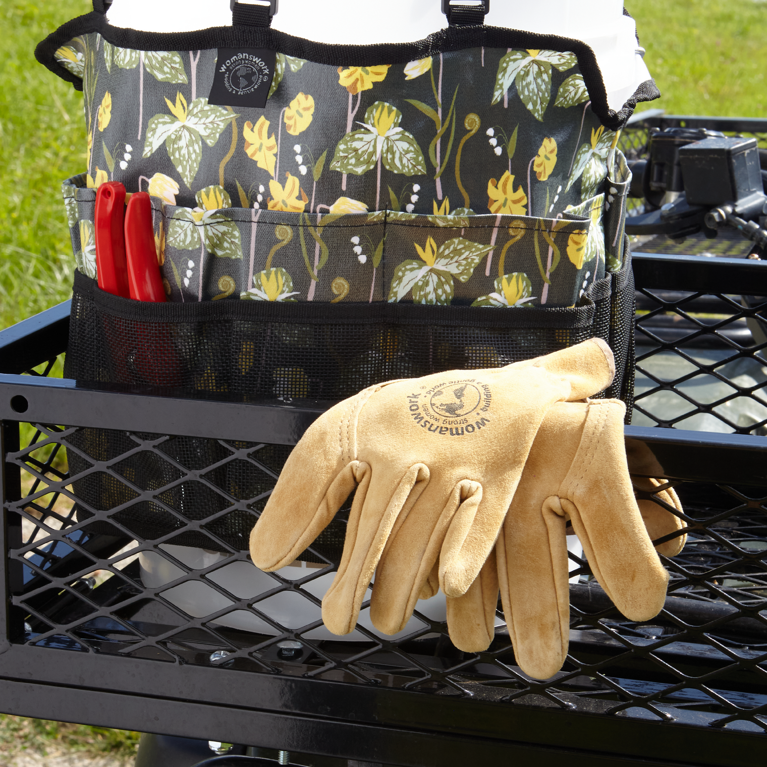 Gardening tool holder with floral pattern and gloves on a black metal cart.