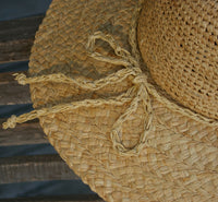 Close-up of a straw hat with a rope tie, blurred background