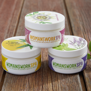 Three jars of Womanswork Spa products on a wooden surface